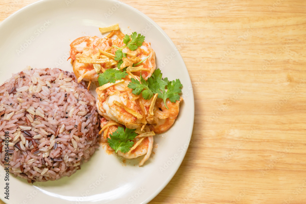 Stir fried shrimp with garlic and coriander leaves serve with cooked mix riceberry, jasmine rice, brown rice and red rice. Top view and copy space Stir fried shrimp with garlic and coriander leaves serve with cooked mix riceberry, jasmine rice, brown rice and red rice. Top view and copy space