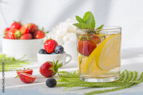 Infused water made from blueberry strawberry and lemon in sparkling mineral water look so freshness and healthy. Mixed fruit mojito on wood table with copy space. Summer refreshing drink concept. Ice 