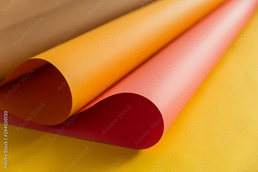 Pink and orange papers bending together over yellow color paper in abstract form. Abstract color paper background. Pink and orange papers bending together over yellow color paper in abstract form. Abstract color paper background.