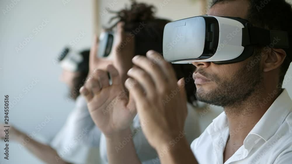 Young man wearing VR glasses at office. Closeup shot of young people experiencing virtual reality headset. Technology concept Young man wearing VR glasses at office. Closeup shot of young people experiencing virtual reality headset. Technology concept