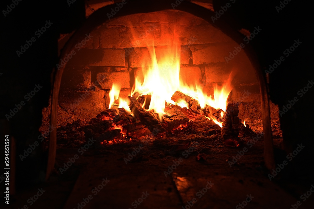 Burning wood in the fireplace, Wood burning in a cozy fireplace at home in interior. Fireplace as a piece of furniture. Christmas New Year concept decorations.