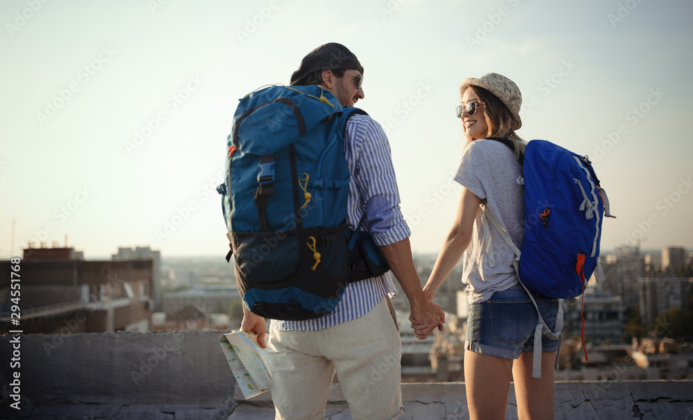 Multiethnic traveler couple using map together on sunny day - obrazy, fototapety, plakaty 