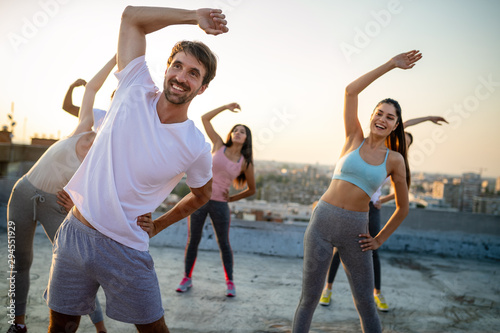 Group of friends fitness training together outdoors living active healthy