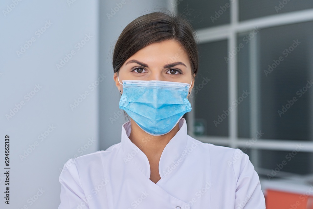Portrait of young woman doctor nurse in protective medical face mask Portrait of young woman doctor nurse in protective medical face mask