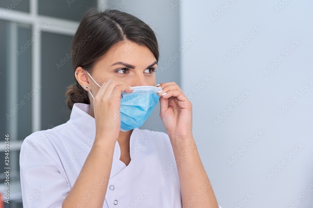 Portrait of young woman doctor nurse in protective medical face mask Portrait of young woman doctor nurse in protective medical face mask