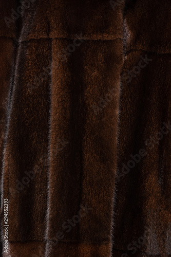 Natural dark brown shiny fur texture with beautiful folds in the form of waves