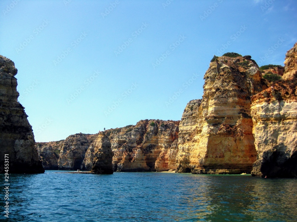 Fototapeta premium Algarve coast with rocky formations. Atlantic coast landscape in Algarve region. Seashore and caves seen from the Atlantic Ocean. Area near Lagos, Portugal, Europe