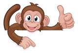 A monkey cartoon character animal peeking over a sign and pointing at it while doing a thumbs up
