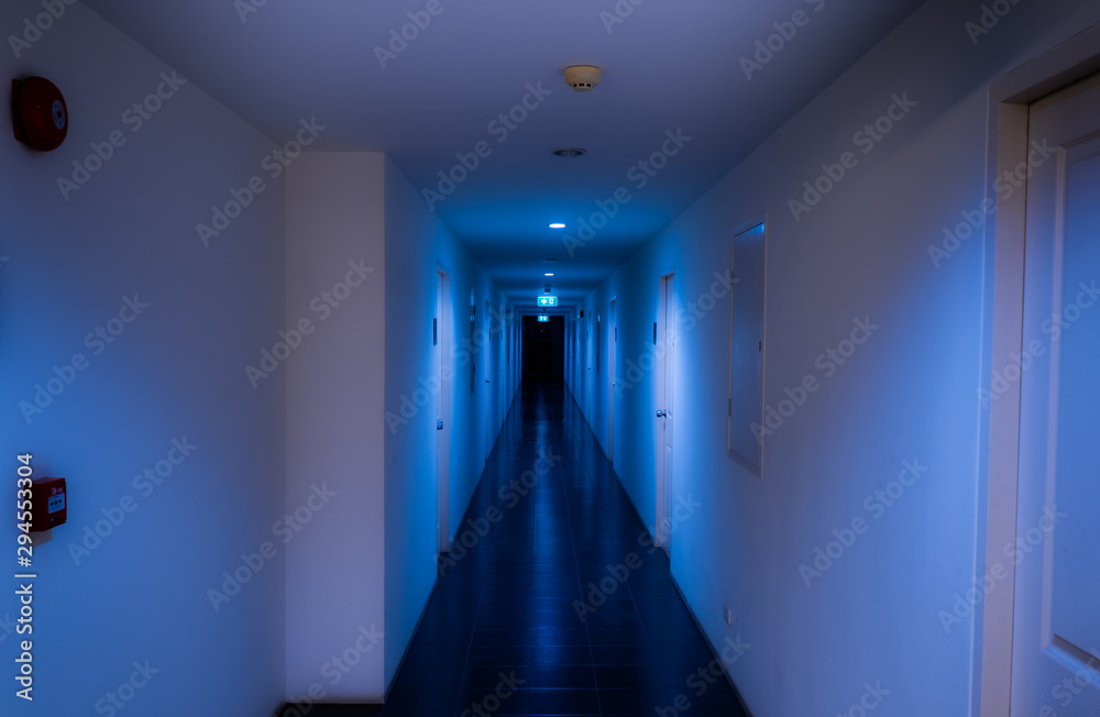 building aisle in blue tone with fire exit sign and alarm