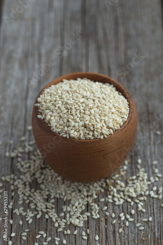 scoop of healthy sesame seeds on sesame seeds background