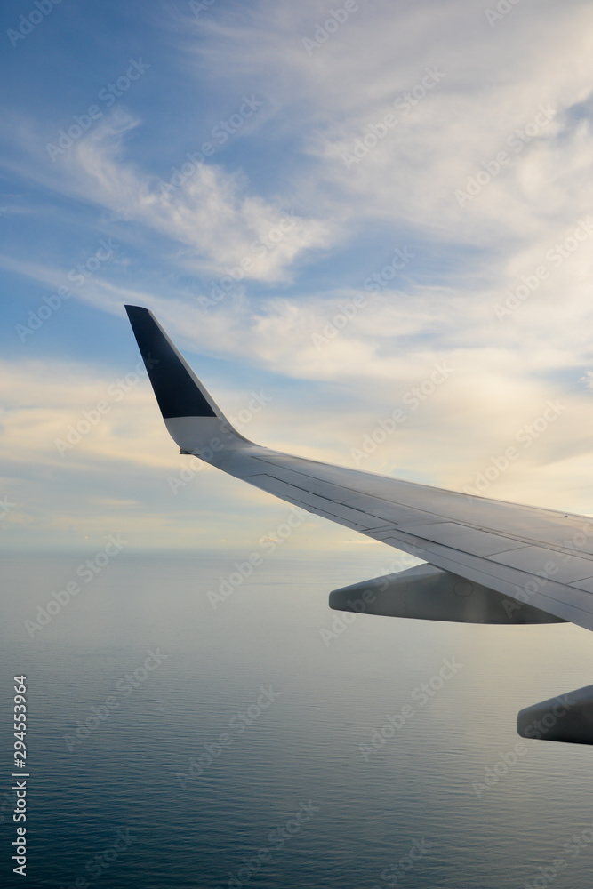 Obraz premium Wing of an airplane flying above the clouds
