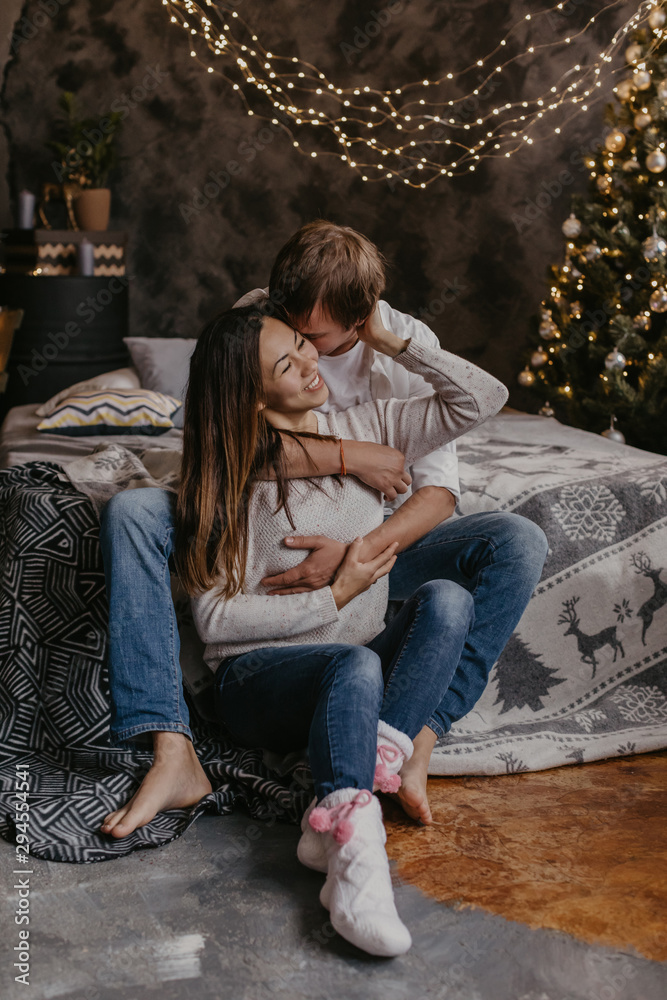 Naklejka premium Romantic couple in love feeling happiness about their romance spending christmas eve together- Image