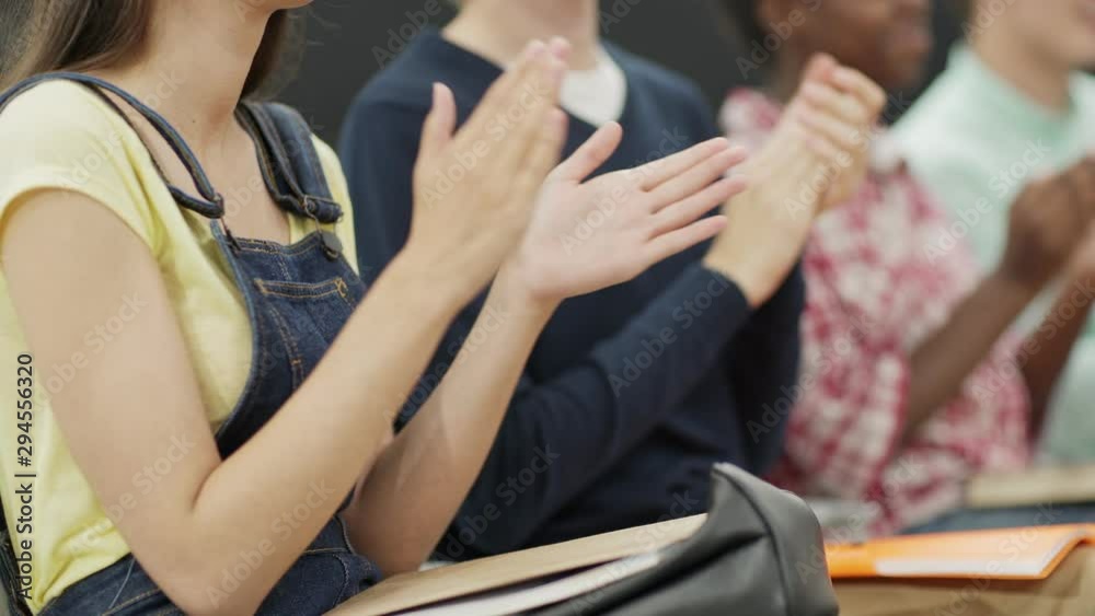 Tracking closeup shot of group of unrecognizable diverse college students clapping hands after presentation at educational conference, side view selective focus Tracking closeup shot of group of unrecognizable diverse college students clapping hands after presentation at educational conference, side view selective focus