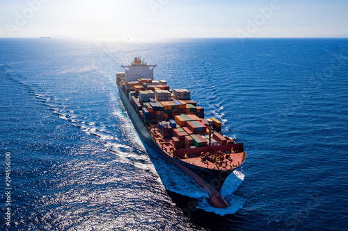 Luftaufnahme ein beladenen Containerschiffes bei voller Fahrt über blauem Meer photo