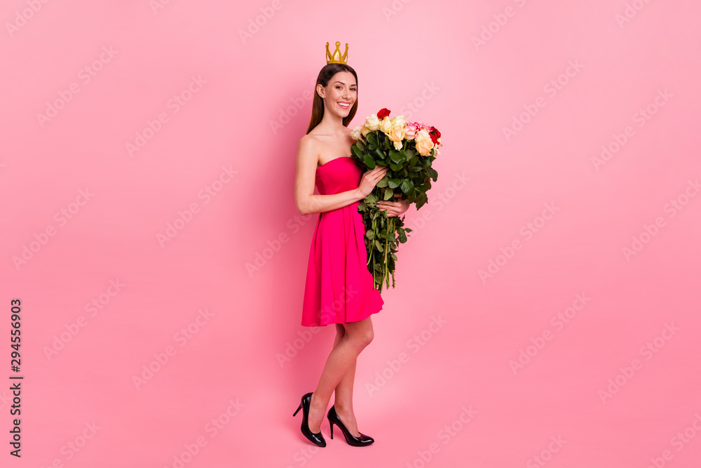 Full length body size view of her she nice-looking attractive lovely cheerful cheery girl holding in hands big large bouquet different roses stem wearing diamond crown isolated over pink pastel color