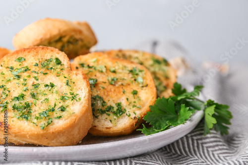 Slices of toasted bread with garlic and herbs on table, closeup