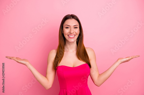 Portrait of her she nice-looking attractive lovely charming cheerful cheery glad content red haired girl holding invisible things on palms isolated over pink pastel color background © deagreez