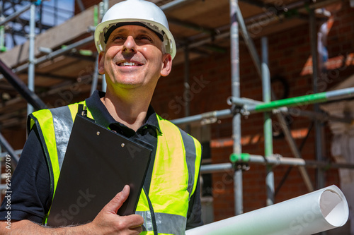 Fotografie Male Builder Architect Contractor on Building Site Clipboard and Plans