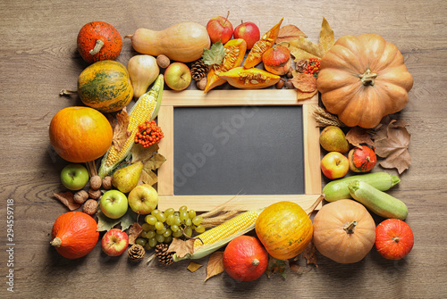 Chalkboard with space for text  autumn vegetables and fruits on wooden background  flat lay. Happy Thanksgiving day