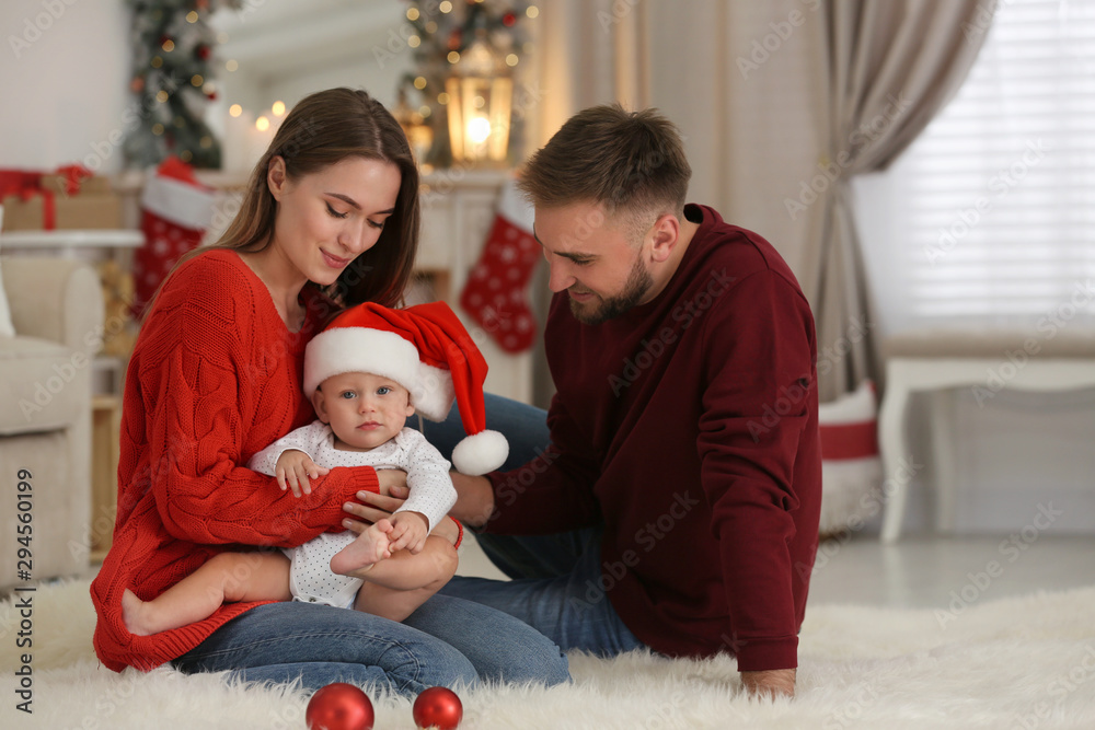 Obraz premium Happy family with cute baby in room decorated for Christmas holiday