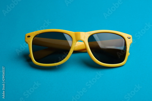Stylish sunglasses on blue background. Fashionable accessory