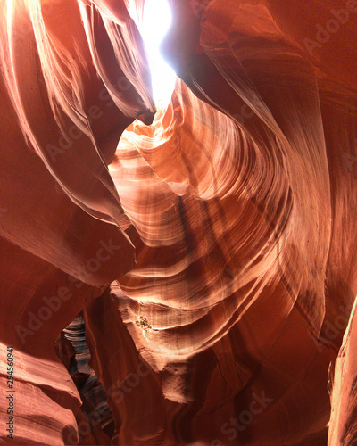 Looking up at Low Antelope canyon, stunning view, eroded red sandstone walls, sun light falling on red canyon walls directly above