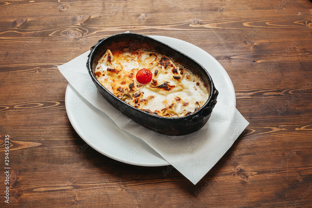 Fototapeta premium Italian baked lasagna on wooden table