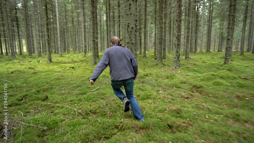 Man running through the green forest. Slow motion shot Man running through the green forest. Slow motion shot