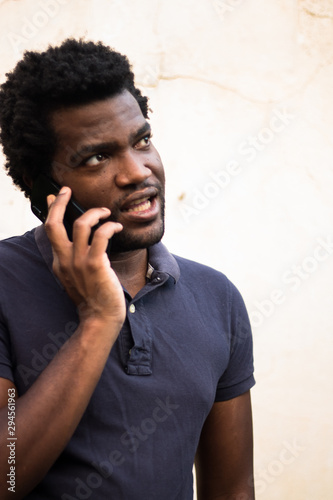Fototapeta Naklejka Na Ścianę i Meble -  Black young man calling on the phone