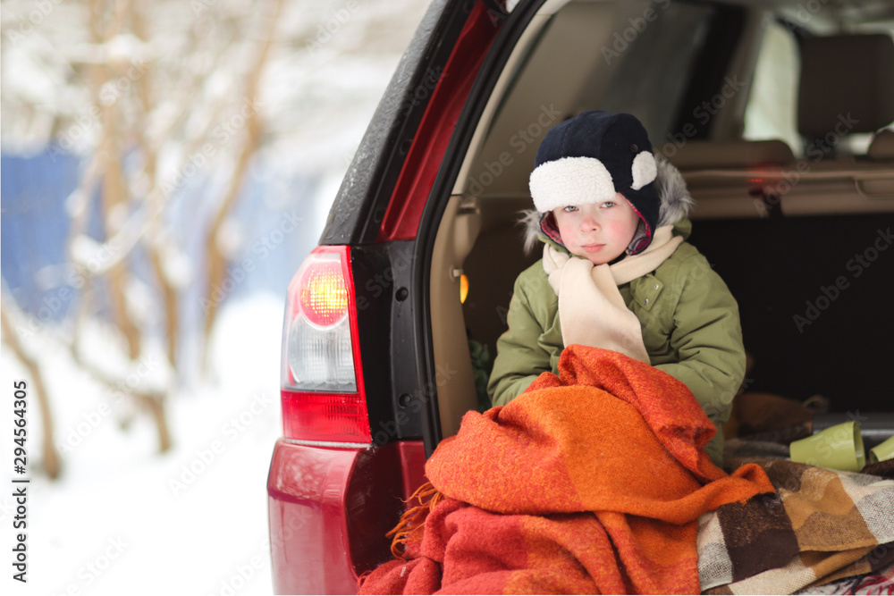 froze boy wrapped in blanket in the trunk of car