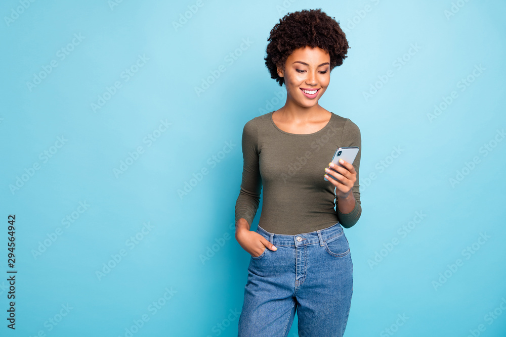 Photo of cheerful cute nice attractive black woman wearing green sweater standing confidently with her hand in pocket smiling cheerfully isolated over vivid blue color background Photo of cheerful cute nice attractive black woman wearing green sweater standing confidently with her hand in pocket smiling cheerfully isolated over vivid blue color background