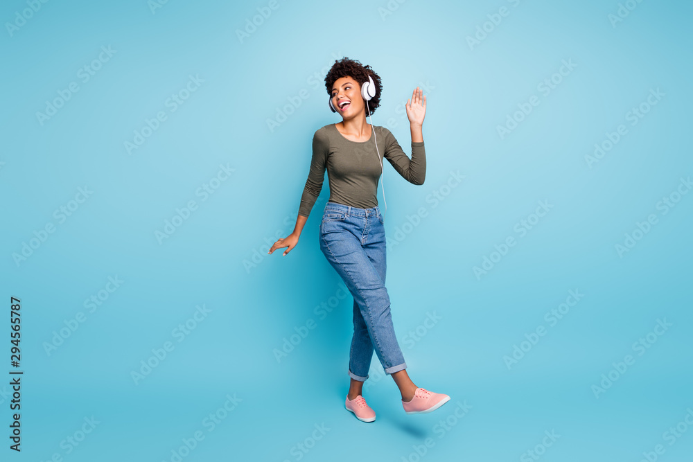 Full length body size photo of cheerful excited cute ecstatic careless black clubber hanging out in jeans denim green shirt dancing isolated over blue vivid color background