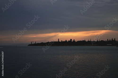 Sunset on distant land over the sea © Vinay V