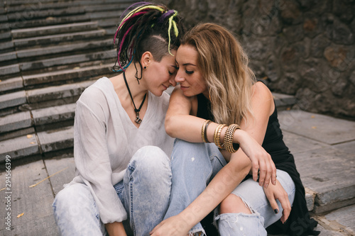 Gay love story. Twon beautiful woman sitting on stairs and hugging. Romantic and relax photo