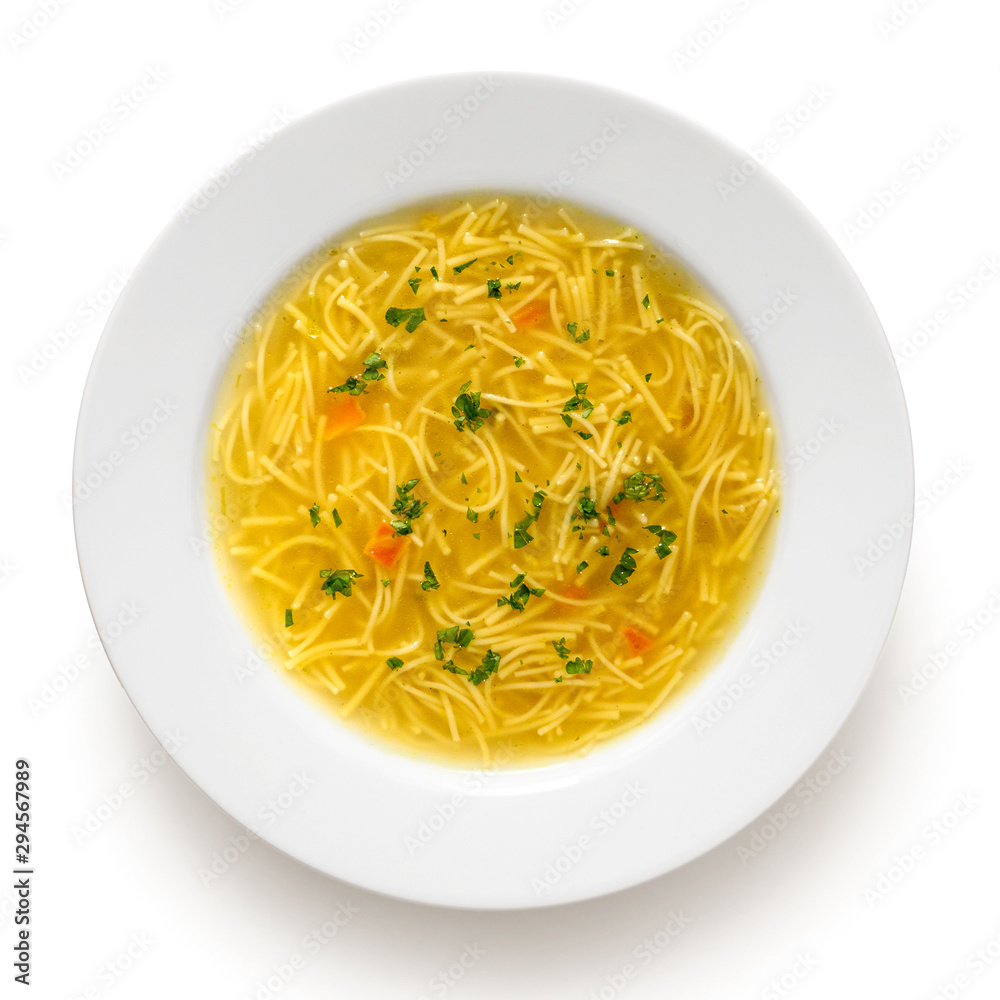 Instant chicken noodle soup in a white ceramic soup plate isolated on white. Top view. Chopped parsley.
