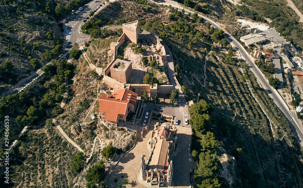 Aerial drone point of view directly from above Sanctuary of Santa Maria Magdalena monastery rooftop and surroundings countryside located in Novelda town, spanish Art Nouveau masterpiece, Spain