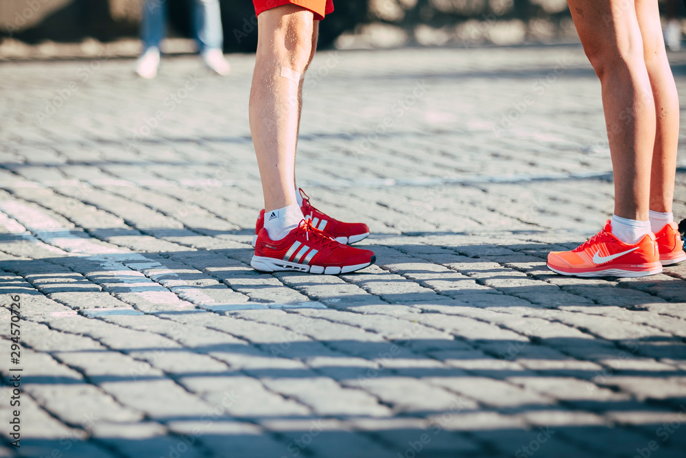 legs runners: man in Adidas running shoes and girl in Nike running shoes  during Marathon From Europe To Asia, Ekaterinburg, Russia - August 01, 2015  Stock Photo | Adobe Stock