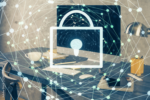 Double exposure of desktop with computer and lock icon hologram. Concept of data safety.