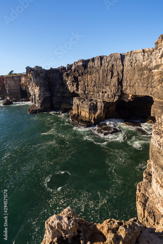 Scenic view of the Boca do Inferno (Hell's Mouth) in Cascais, Portugal, on a sunny day. It's a chasm in the seaside cliff and popular tourist attraction.
