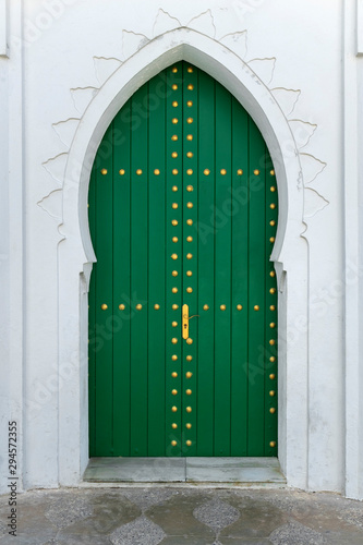 Green painted wooden door with gold colored decoration