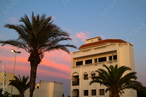 Traditional built apartments with palm trees at the boulevard of Assilah photo