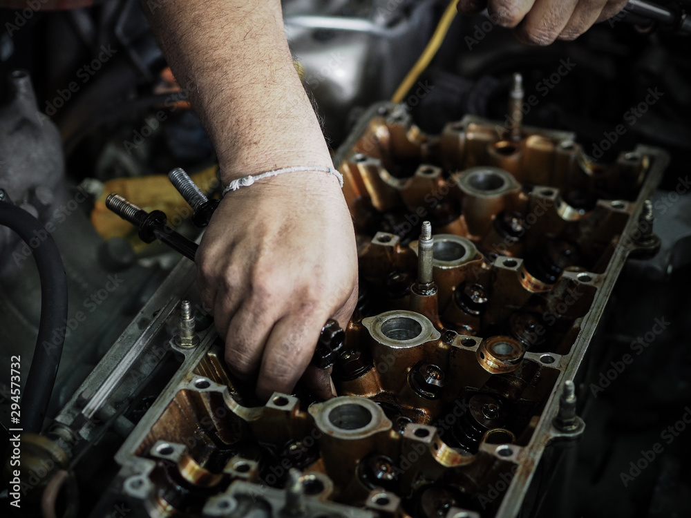 Auto mechanic working in garage. Remove the cover part. Authentic close-up Auto mechanic working in garage. Remove the cover part. Authentic close-up