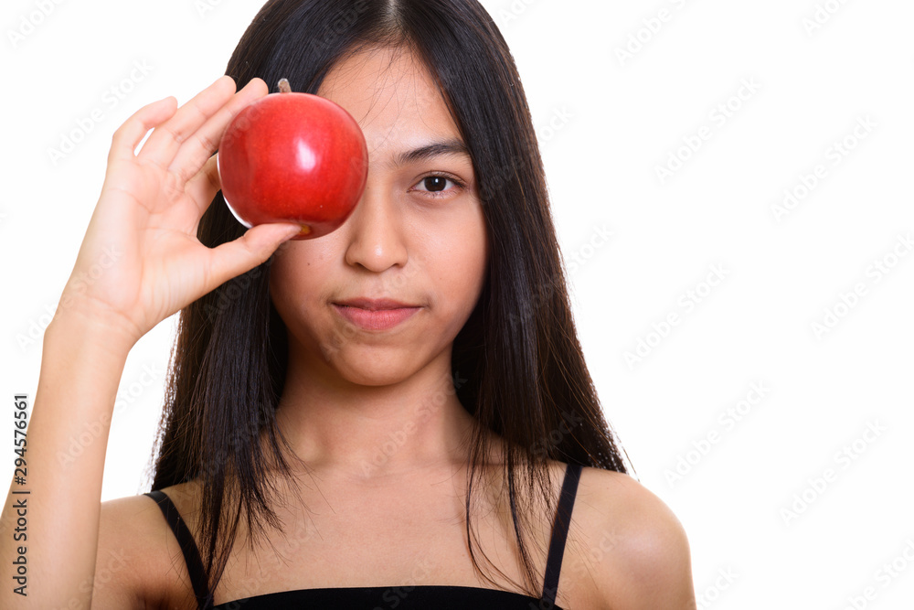 Studio shot of young Asian teenage girl covering eye with red ap