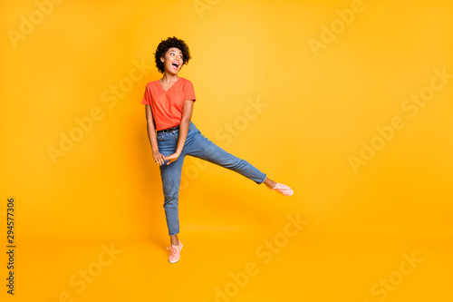 Full length body size photo of cheerful cute nice rejoicing overjoyed african youngster seeing her favorite goods discounted wearing jeans denim sneakers isolated vivid color background
