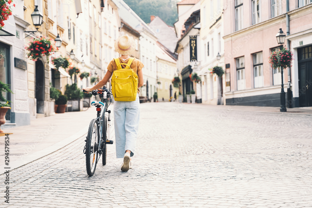 Girl with backpack and bicycle explores Ljubljana. Travel Slovenia