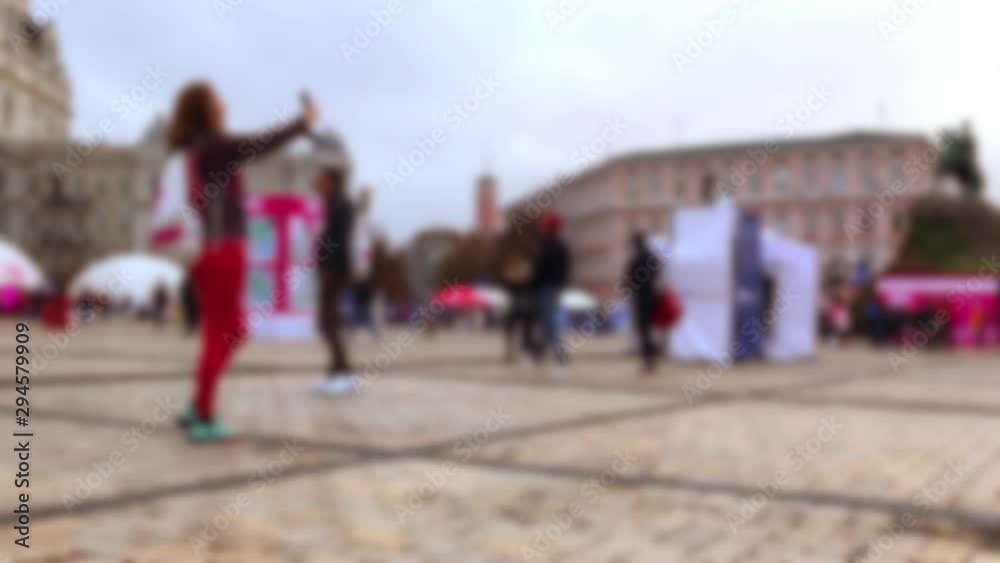 Blurred Silhouette of a woman taking a selfie on the background of a large bright city square. Around the camera around a young woman. Background for a video about urban cultural events. Blurred Silhouette of a woman taking a selfie on the background of a large bright city square. Around the camera around a young woman. Background for a video about urban cultural events.