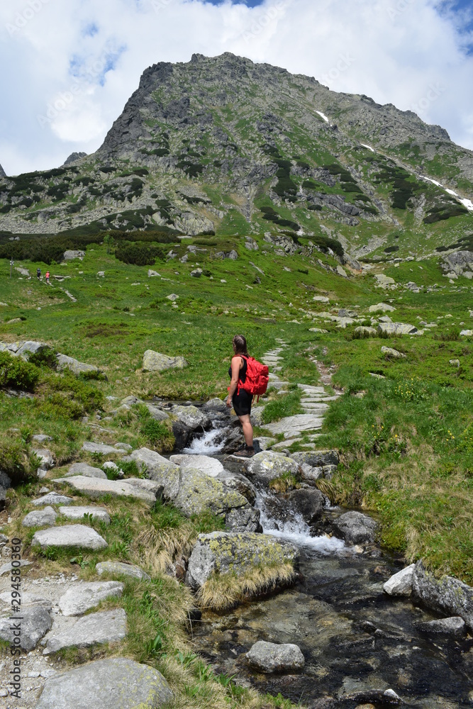 A girl with a backpack hiking in the polish mountains