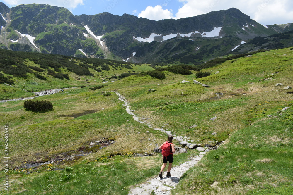 A girl with a backpack hiking in the mountains A girl with a backpack hiking in the mountains