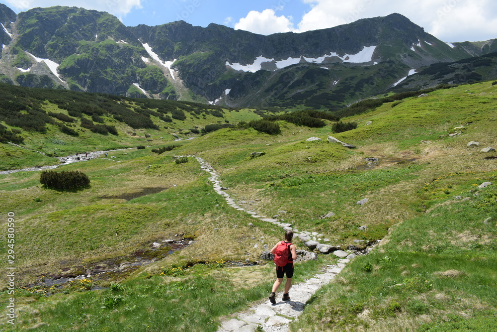 A girl with a backpack hiking in the mountains