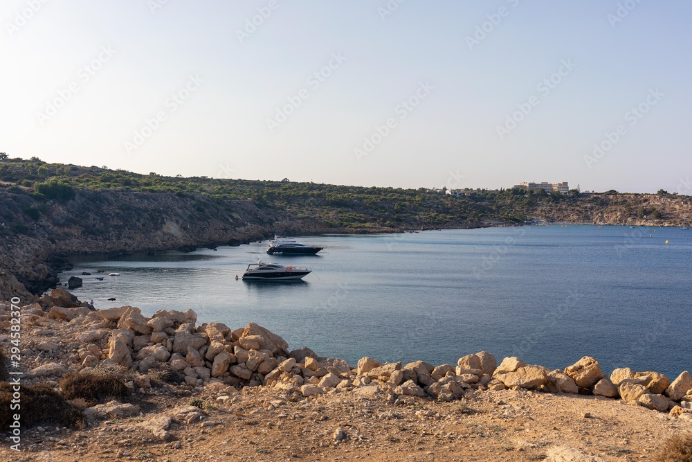 Two boats anchored in the bay while sunset in Cyprus